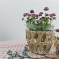 Vase en verre de fleurs enveloppé d'herbe